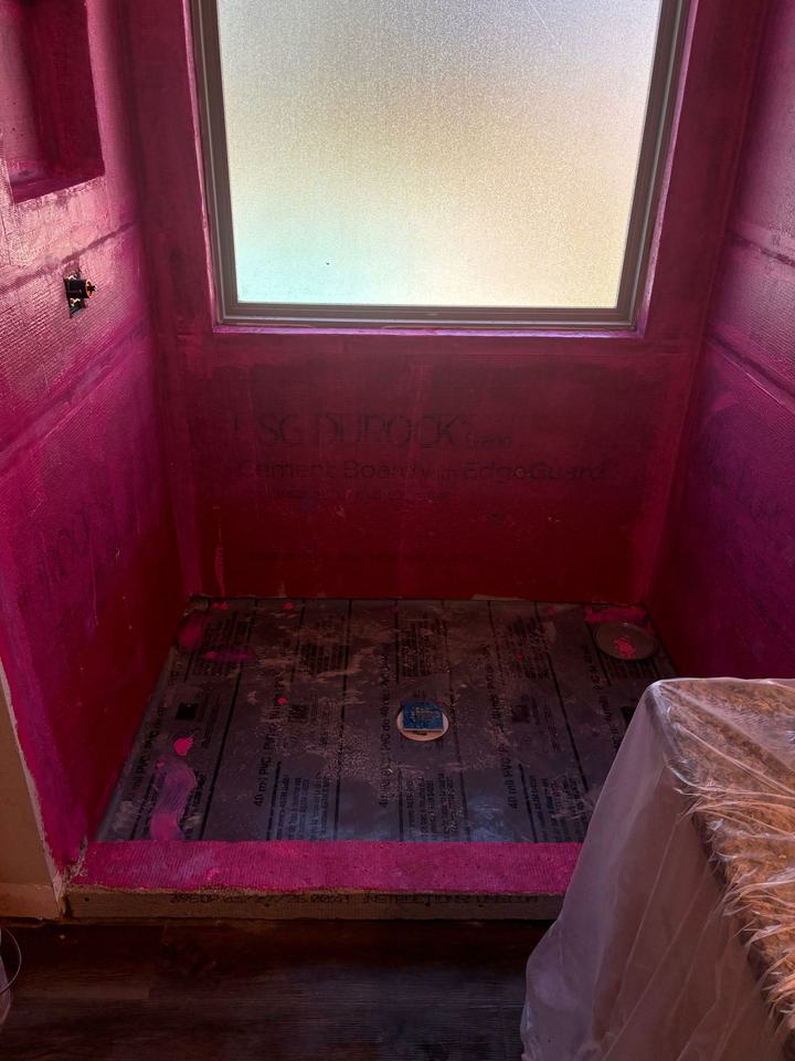 Waterproofing membrane rolled over cement board, wrapped into the window opening