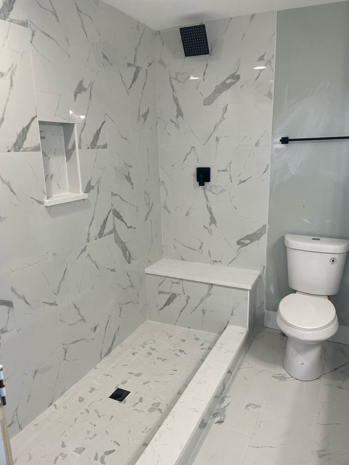 Marble-look shower with niche, bench and black rain head