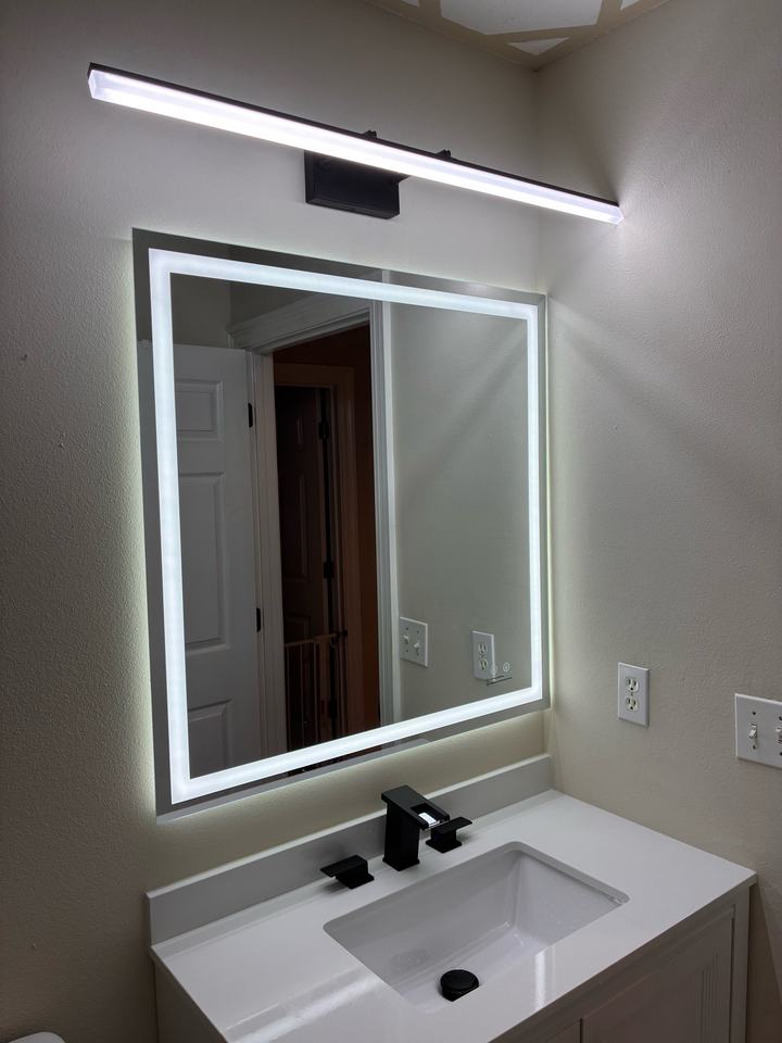 White vanity with backlit mirror and light bar